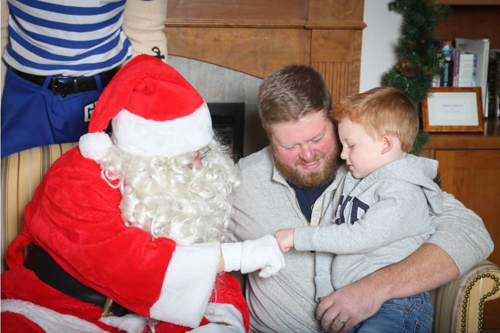 Santa and boy giving each other knuckles